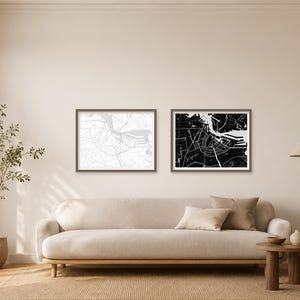 Könnte beinhalten: Zwei rechteckige gerahmte Wandkunst-Drucke mit detaillierten Stadtplan-Illustrationen. Ein Druck zeigt einen weißen Hintergrund mit schwarzen Linien, während der andere einen schwarzen Hintergrund mit weißen Linien aufweist.