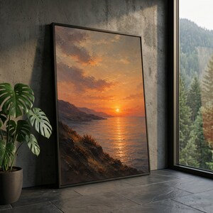 Op de afbeelding: Een rechthoekig ingelijst kunstwerk aan de muur met een olieverfschilderij van een zonsondergang aan de kust. De scène toont een heldere oranje zon die ondergaat boven een kalme oceaan, met ruige kliffen en zachte, getextureerde wolken.