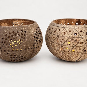 May include: Two brown coconut shell bowls with circular cutouts. The left bowl features a swirling pattern of small holes, while the right bowl displays a geometric grid of triangles and circles. Both bowls have a natural, textured exterior finish.