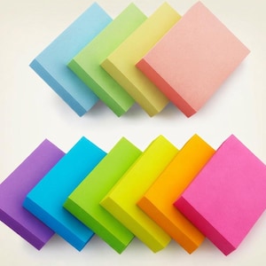 May include: A collection of ten rectangular sticky note pads arranged in two rows. The top row features light blue, light green, pale yellow, and peach pads. The bottom row includes purple, bright blue, lime green, yellow, orange, and hot pink pads.
