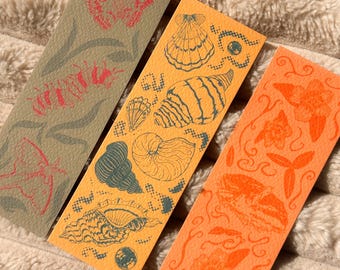 Conjunto de tres marcapáginas ilustrados con temas de naturaleza, conchas marinas y animales.