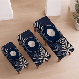 May include: Three rectangular benches of varying sizes, each featuring a dark navy blue fabric upholstery with a white circular center design and a pattern of light gray and dark blue palm leaves extending from the corners across the surface.
