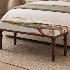 May include: A rectangular upholstered bench with four dark brown turned wooden legs. The seat features a cream-coloured fabric top printed with a colourful, detailed illustration of a large dragonfly, various small flowers, and botanical elements.