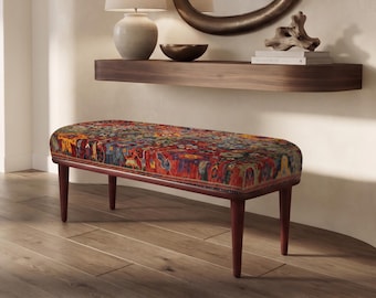 May include: A rectangular bench featuring a multi-coloured, intricate floral and geometric patterned fabric upholstery. The seat is supported by four tapered, dark brown wooden legs, providing a stable base for the cushioned top surface.