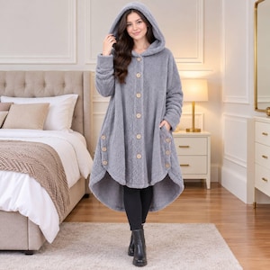 May include: A long-sleeved, hooded fleece coat in a solid gray color. The coat features a high-low hemline, a front button closure with light-colored wooden buttons, and additional decorative buttons along the side pockets and hem area.