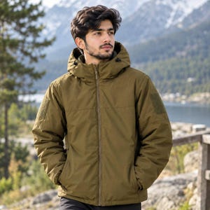 May include: An olive green hooded jacket with a full-length front zipper, long sleeves, and rectangular hook-and-loop patches on each shoulder. The jacket features a high collar, a drawstring hood, and two side pockets, constructed from a solid fabric.