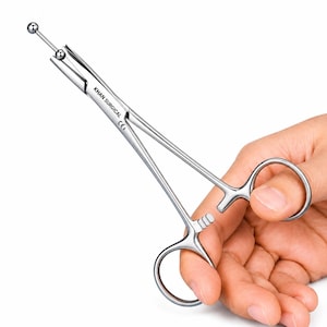 May include: A silver-coloured stainless steel surgical instrument with ring handles, a locking ratchet mechanism, and a long shaft ending in a ball-tipped probe. The tool features the engraved text KHAN SURGICAL and CE on the side of the shaft.