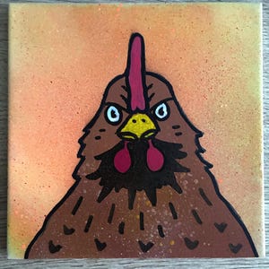 Può includere: Una piastrella quadrata in ceramica con un'illustrazione dipinta a mano di una gallina marrone con becco giallo, cresta rossa e bargigli rossi. La gallina è centrata su uno sfondo sfumato arancione e giallo maculato con contorni neri.