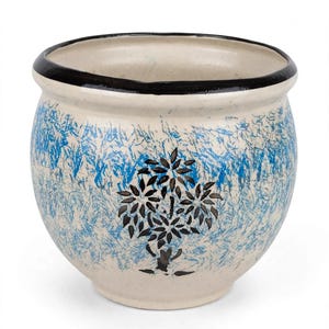 May include: A 25.4 cm large planter with a cream-coloured base, featuring a black rim and a central black tree motif. The exterior surface is decorated with a textured blue sponge-painted pattern that surrounds the central tree design.