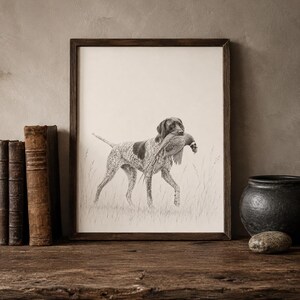 Puede incluir: Un dibujo a lápiz en blanco y negro enmarcado de un perro de muestra alemán de pelo corto de pie en hierba alta mientras sostiene un faisán en la boca. La obra está en un marco de madera oscura y muestra al perro en una pose de caza.