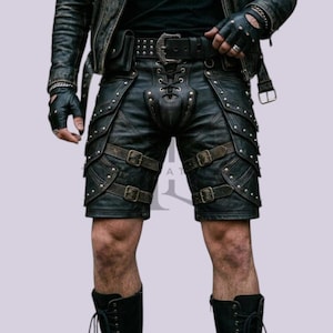 May include: Black leather shorts featuring a lace-up front detail, multiple adjustable straps with metal buckles, and silver-toned stud embellishments. The shorts are paired with a matching leather jacket, fingerless gloves, and black lace-up boots.