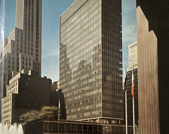 May include: A book cover with a photograph of a modern skyscraper in a city. The title of the book is "The Photography of Architecture and Design" by Julius Shulman. The subtitle is "Photographing Buildings, Interiors and the Visual Arts."
