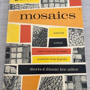 以下が含まれることがあります： Doris & Diane Lee Allerによる「mosaics」というタイトルのヴィンテージ本。表紙は、オレンジ、黄色、赤、黒、白のブロックを使ったモザイクデザインです。この本はSunsetシリーズのもので、材料、方法、プロジェクトに関する情報が含まれています。