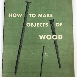 May include: A green book cover with the title "HOW TO MAKE OBJECTS OF WOOD" in black text. The Museum of Modern Art is listed as the publisher. The cover features three black nails.