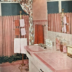 Puede incluir: Un ba&ntilde;o con azulejos rosas, un tocador blanco y un lavabo de porcelana rosa. El ba&ntilde;o tiene un suelo de baldosas rosas y un toallero de metal dorado con toallas rosas y marrones.