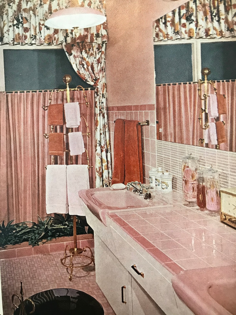 Puede incluir: Un ba&ntilde;o con azulejos rosas, un tocador blanco y un lavabo de porcelana rosa. El ba&ntilde;o tiene un suelo de baldosas rosas y un toallero de metal dorado con toallas rosas y marrones.