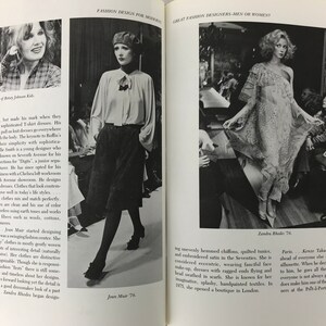 May include: A black and white photograph of a fashion designer, Jean Muir, wearing a white blouse and black trousers. The photo is from a fashion magazine and includes the text "Jean Muir 76".