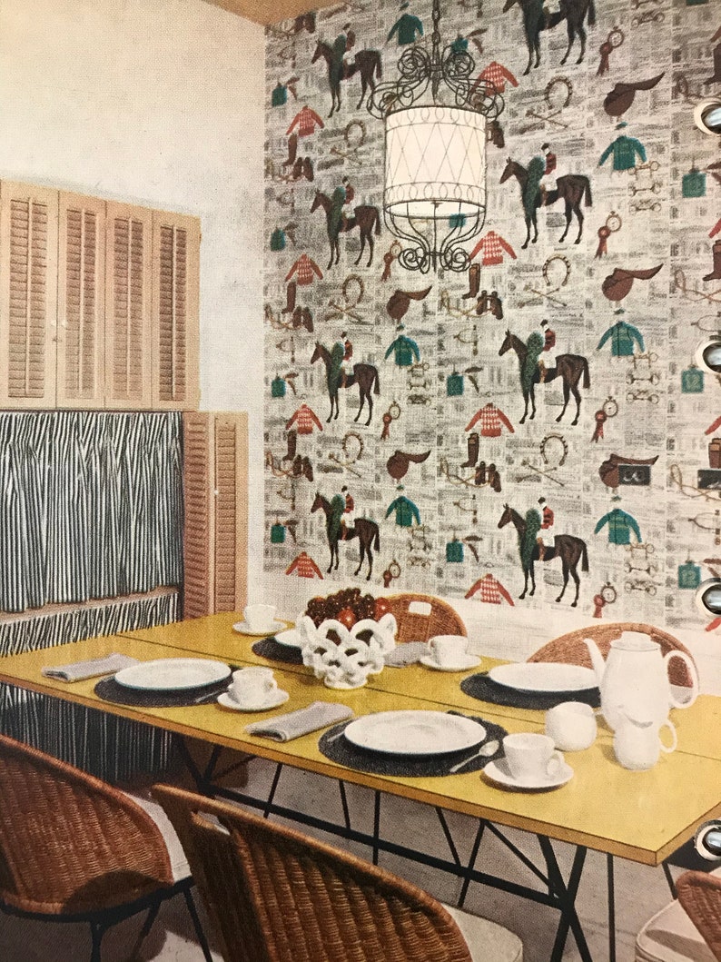 Puede incluir: Una mesa de comedor amarilla con cuatro sillas de mimbre. La mesa est&aacute; puesta con platos blancos, cubiertos y un cuenco blanco lleno de manzanas rojas. La pared detr&aacute;s de la mesa est&aacute; cubierta con papel tapiz con un tema de carreras de caballos.