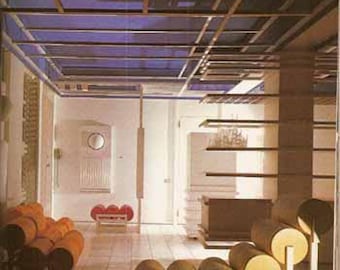 May include: A room with a blue ceiling and a white wall. There are several orange and yellow modular seating units in the room. The seating units are made of individual pieces that can be arranged in different ways.