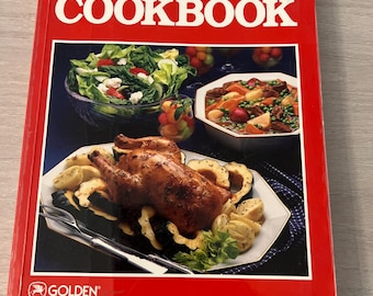May include: A red hardcover Betty Crocker's COOKBOOK with a white title. The cover features a photograph of a roasted chicken, a green salad, a bowl of stew, and a small glass of fruit. The Golden logo is printed in the bottom left corner.