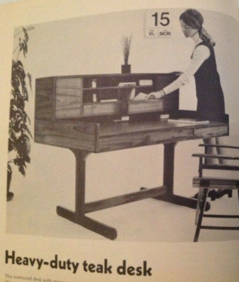 May include: A heavy-duty teak desk with a drawer and shelves. The desk has a unique design with a wide base and a single drawer. The desk is made of dark wood and has a natural finish.