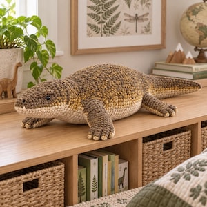 May include: A large, handmade crochet lizard plush toy featuring a textured body in shades of brown, tan, and cream. The stuffed animal has a long tail, four short legs with visible toes, and small black eyes, crafted with detailed yarn stitching.