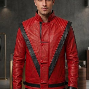 May include: A red leather jacket featuring black V-shaped panels on the chest, a high collar with ribbed detailing, and a front button closure. The sleeves include black cuffs with adjustable straps, and the hem features a black leather band.