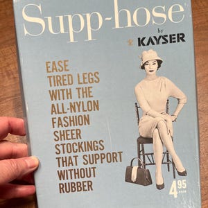 May include: A blue and white box with the text "Supp-hose by Kayser" and an illustration of a woman wearing sheer stockings. The text on the box reads "Ease tired legs with the all-nylon fashion sheer stockings that support without rubber". The price is listed as "4.95 a pair".