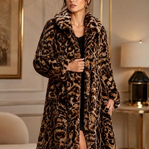 Pode incluir: Um casaco comprido com padrão de leopardo em tons de castanho, preto e bege. A peça é feita de pelo sintético espesso e texturizado, com uma gola larga, mangas compridas e uma silhueta de corte reto que cai abaixo dos joelhos.