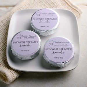 May include: Three silver-wrapped shower steamers with a lavender scent. Each steamer has a label that reads "Treefort Naturals Soap Company" and "Shower Steamer Lavender" with a net weight of 2 ounces.