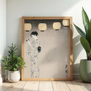 Peut inclure: Une impression d'art encadrée représentant une personne en kimono floral tenant un appareil photo, sous quatre lanternes en papier suspendues sur un fond neutre. L'œuvre comporte des caractères calligraphiques japonais noirs en bas à droite.