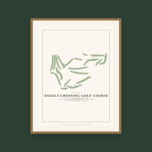 May include: A framed print featuring a top-down map of the Angels Crossing Golf Course in Vicksburg, Michigan. The design includes green fairways, sand traps, and text detailing the architect, establishment year, length of 7,158 yards, and par 72.