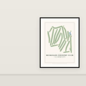 May include: A framed print of the Muskegon Country Club golf course layout. The map features light green fairways on a cream background with a small blue water hazard. Text includes the club name, location, architect, year, and course length.