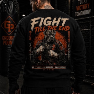 Könnte beinhalten: Ein schwarzes Langarm-Sweatshirt mit einem Grafikdruck auf der Rückseite, der einen Hund in einem Kampfkunst-Gi zeigt. Der Text lautet FIGHT TILL THE END, NO EXCUSES NO REGRETS ONLY VICTORY und STAY HARD, ergänzt durch japanische Schriftzeichen und eine rote Sonne.