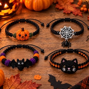 May include: Four adjustable black cord bracelets featuring crocheted Halloween charms. One bracelet has an orange pumpkin, one a silver spiderweb with a black spider, one a black bat with purple and orange beads, and one a black cat face.