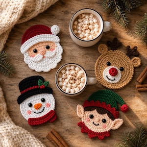 Puede incluir: Cuatro posavasos redondos de ganchillo con personajes navideños: un Santa Claus con gorro rojo, un reno marrón con astas y nariz roja, un muñeco de nieve con sombrero negro y bufanda roja, y un elfo con gorro verde y orejas puntiagudas.