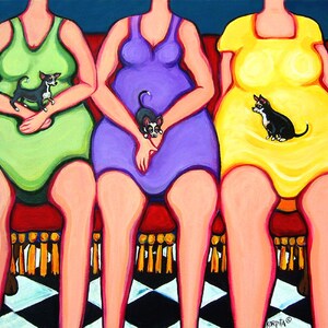 Puede incluir: Tres mujeres con vestidos coloridos est&aacute;n sentadas en un sof&aacute; rojo con suelo de ajedrez negro y blanco. Cada mujer sostiene un peque&ntilde;o chihuahua negro y blanco.