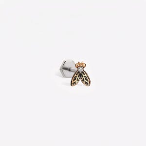 May include: A flat-back stud earring featuring a rose gold-toned insect design with a small clear stone set in the head and black textured detailing on the wings, attached to a silver-toned hexagonal post base.