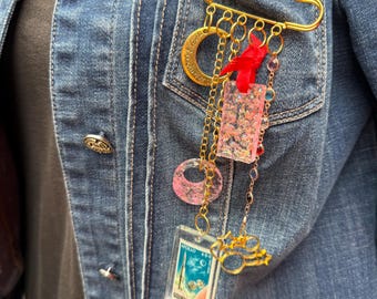 Charms on a safety pin brooch