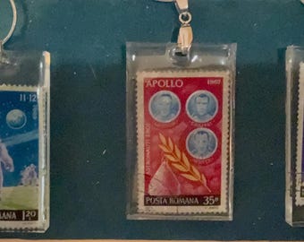 Outer space stamps in resin on a 14” silver chain. Hand made, one of a kind.