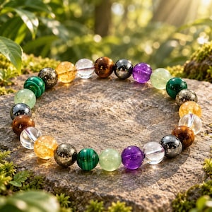 May include: A circular beaded bracelet featuring a variety of polished, spherical gemstones in diverse colours including clear, yellow, brown, dark grey, purple, light green, and deep green, arranged in a repeating pattern on a flexible cord.