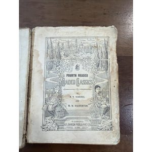 May include: An antique book titled Fourth Reader Graded Classics by F. T. Norvell and M. W. Haliburton, published by B. F. Johnson Publishing Co. The page features a black and white illustration of two children reading amidst floral borders.