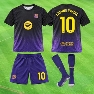 May include: A black and purple soccer jersey set featuring the FC Barcelona crest, a yellow Spotify logo, and the name Lamine Yamal with the number 10 on the back. The set includes matching purple shorts with the number 10 and purple soccer socks.