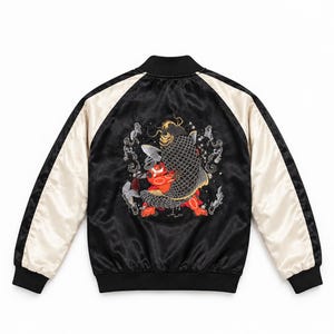 Puede incluir: Una chaqueta bomber de satén negra y color crema con un gran bordado detallado en la espalda. El diseño muestra una figura de piel roja luchando con un gran pez koi de escamas oscuras, rodeado de motivos de nubes grises estilizadas.