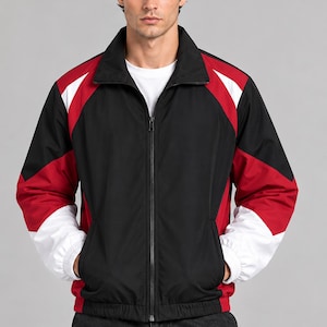 Op de afbeelding: Een zwart, rood en wit gekleurde jack met rits, een hoge kraag, lange mouwen met elastische boorden en een ritssluiting over de hele lengte. Het jack heeft een effen zwart middenpaneel met rode en witte accenten op de schouders en mouwen.