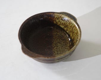 Vintage Japanse yoghurtkom van steengoed met een matte groene glazuurlaag, perfect voor rustige ochtendrituelen.