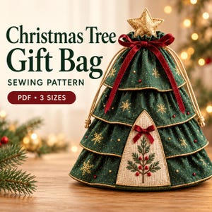 Puede incluir: Un patrón de costura PDF para bolsa de regalo de árbol de Navidad en 3 tamaños. La bolsa es verde oscuro con bordados de copos de nieve dorados, bayas rojas y una estrella dorada. Tiene cierre de cordón con cinta de terciopelo rojo y panel beige.
