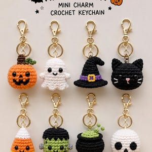 May include: Eight Halloween mini charm crochet keychains featuring a pumpkin, ghost, witch hat, black cat, candy corn, Frankenstein monster, cauldron, and skull. Each item has a gold-tone metal lobster clasp and ring for attachment.