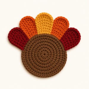 May include: A round, brown crocheted coaster featuring a fan-shaped arrangement of five colorful, rounded petals extending from the top. The petals are colored in alternating shades of dark red, orange, and yellow, creating a turkey-like design.