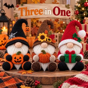 May include: Three crocheted gnomes sitting side by side. The left gnome wears a black hat with a spiderweb and holds a pumpkin. The middle gnome wears a brown hat with a sunflower and leaves, holding a pumpkin. The right gnome wears a red hat with holly and holds a gift.